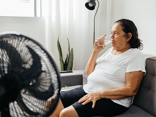 A woman drinks water due to the heat